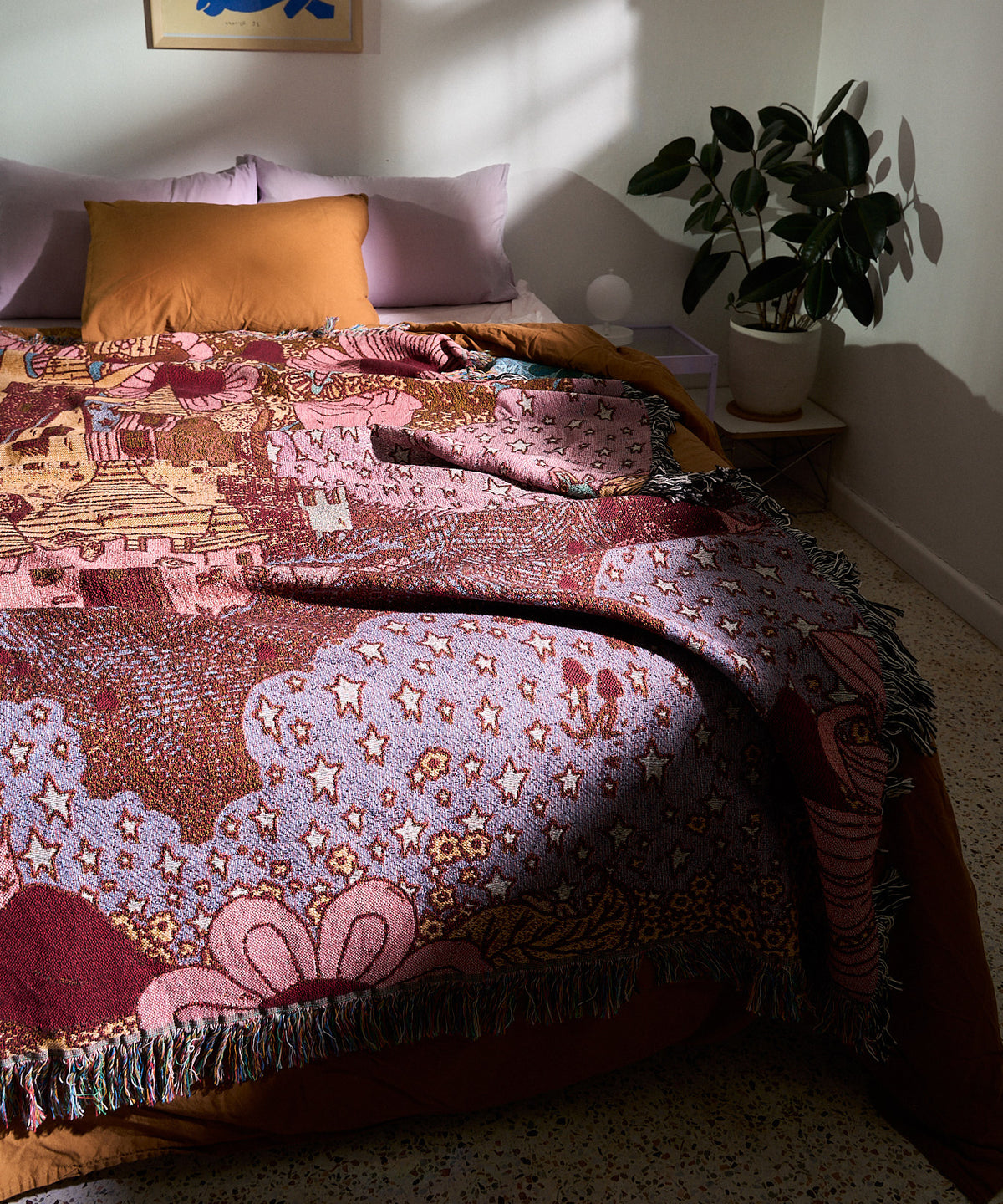 Autumnal Wood woven blanket spread across a bed in a sunlit bedroom