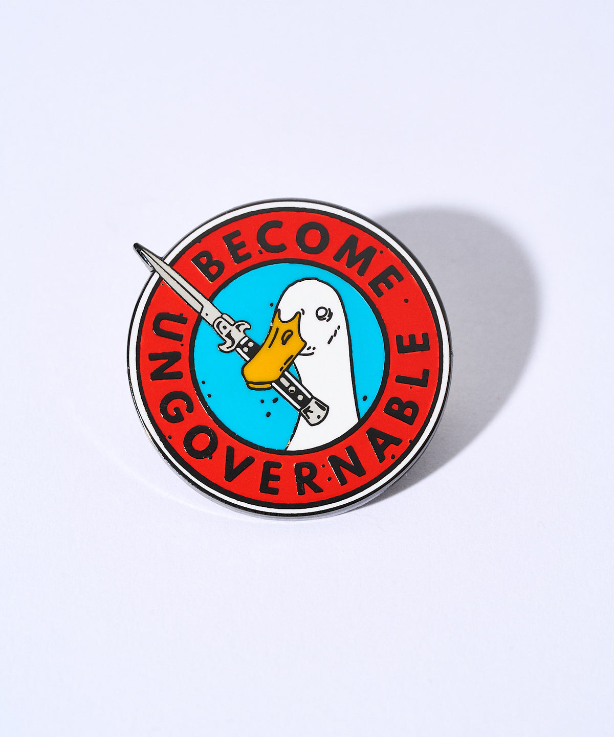 Become Ungovernable enamel pin, a goose holding a knife, on a lavender background
