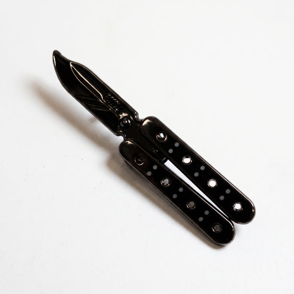 Black Butterfly Knife pin flipped open, a black balisong blade between two black handles with rows of silver dots
