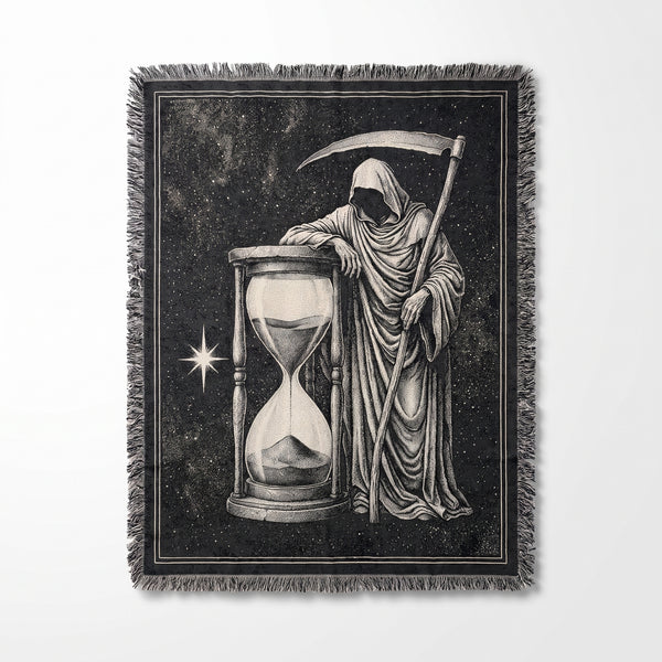 Grim Reaper Hourglass woven blanket showing an engraved hooded reaper with a scythe leaning on a giant hourglass against a starry black background