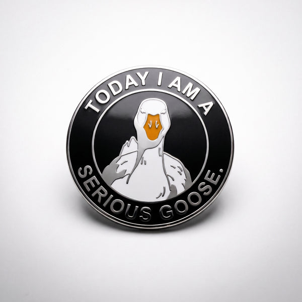 Serious Goose enamel pin, a stern white goose with an orange beak on a round black badge reading Today I Am A Serious Goose in silver