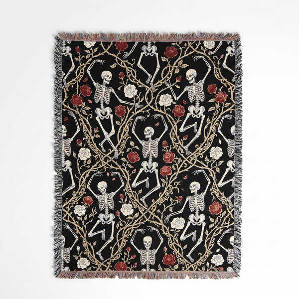 Skeleton And Rose woven blanket showing dancing white skeletons tangled in gold thorny vines with red and white roses on black