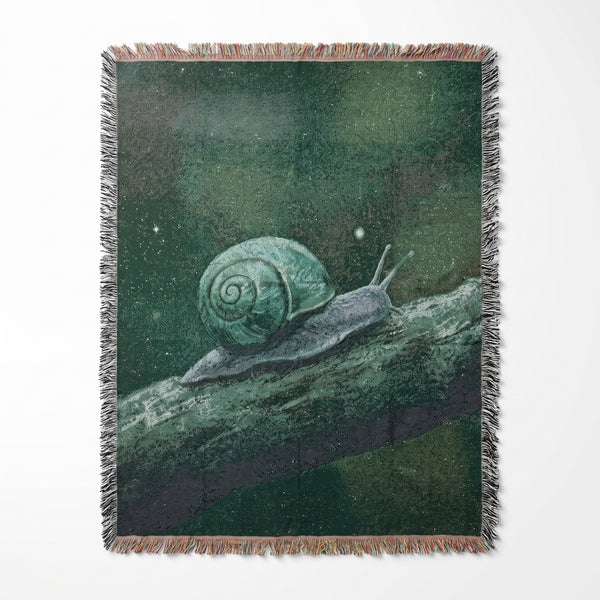 Snail Forest woven blanket showing a pale green snail crawling along a mossy log in a dark misty forest