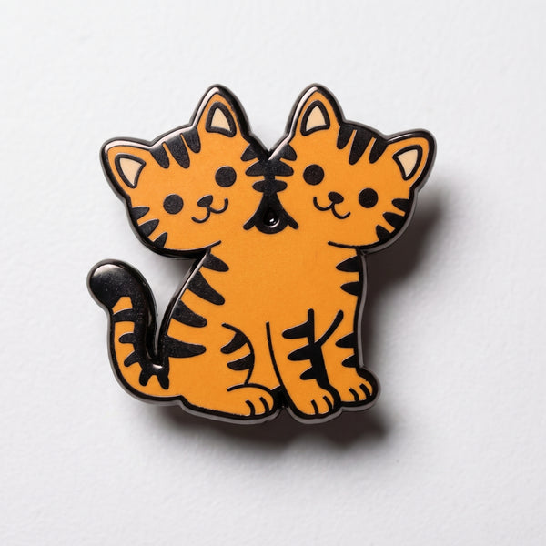 Two Headed Cat enamel pin, a smiling orange tabby cat with two heads and black stripes