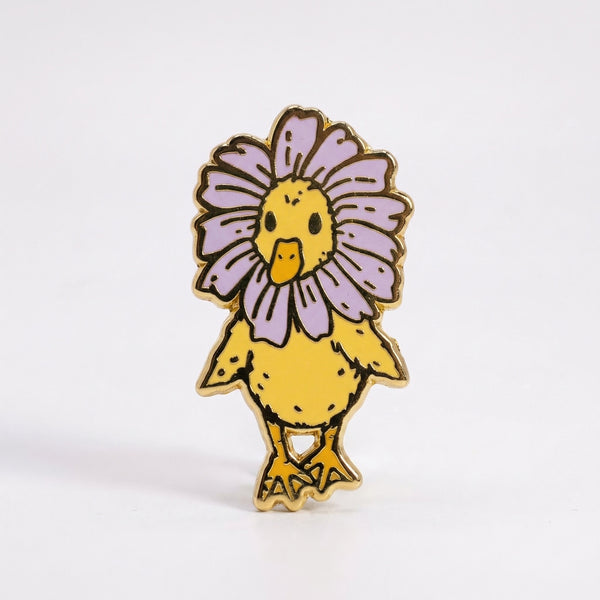 Yellow duckling enamel pin with a purple flower petal collar