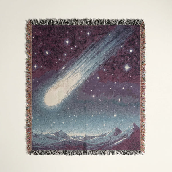 Woven cotton throw blanket with a large comet streaking over mountains and stars.