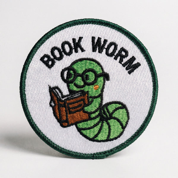 Circular embroidered patch with green book worm character reading a book and text reading BOOK WORM