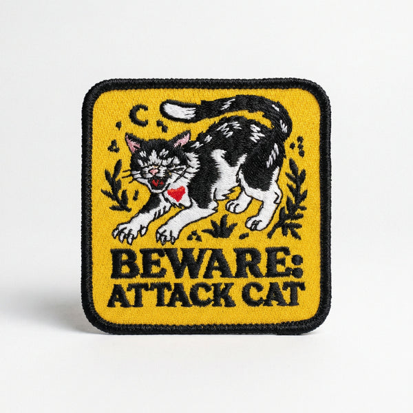 Square yellow embroidered patch with a hissing black and white cat and text reading Beware Attack Cat