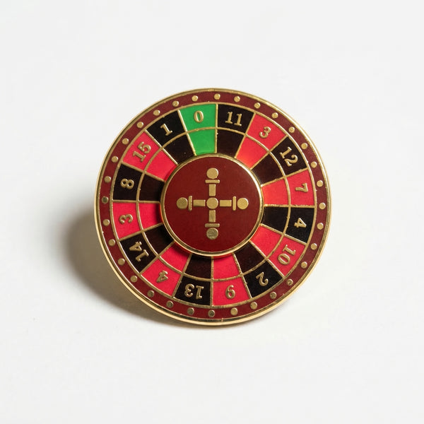 Gold-plated enamel pin shaped like a roulette wheel with a spinning center