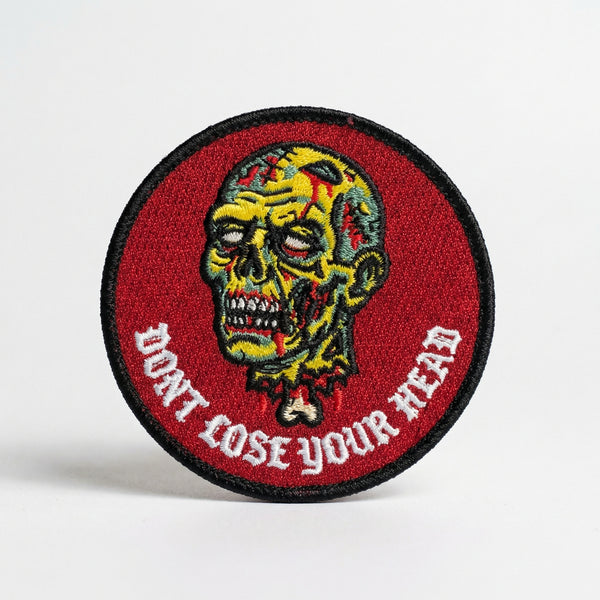 Circular red embroidered patch with a yellow zombie head and text Don't Lose Your Head