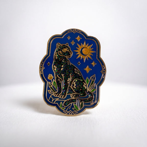 Night Panther enamel pin, a black panther under a gold crescent moon and stars on a navy panel
