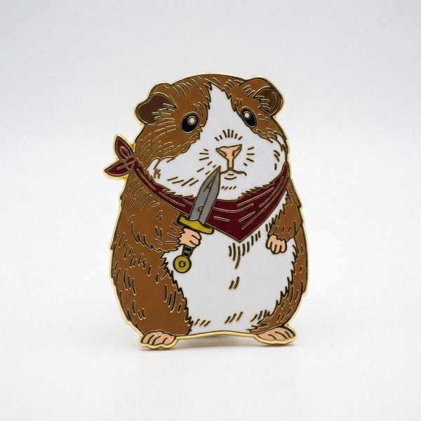 Enamel pin of a brown and white guinea pig holding a dagger and wearing a red bandana
