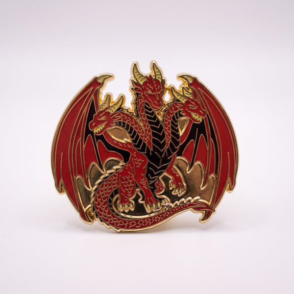 Red Hydra enamel pin, a many-headed red dragon with gold horns and spread wings coiled over its tail