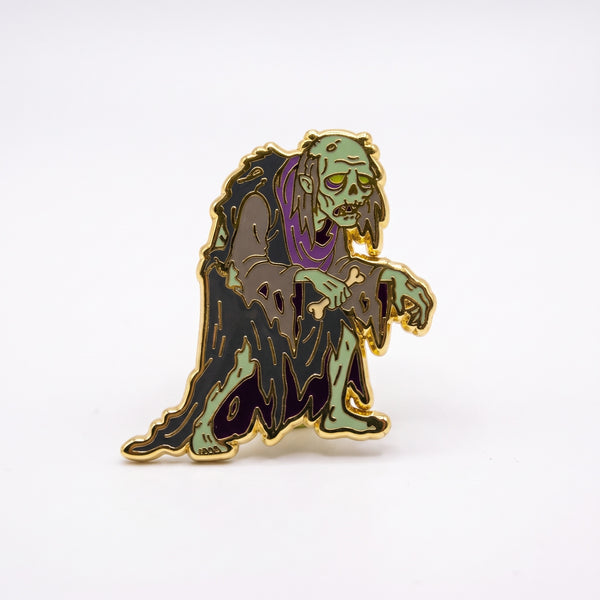 Ghoul enamel pin, a green-skinned ghoul in a tattered gray and purple robe clutching a bone